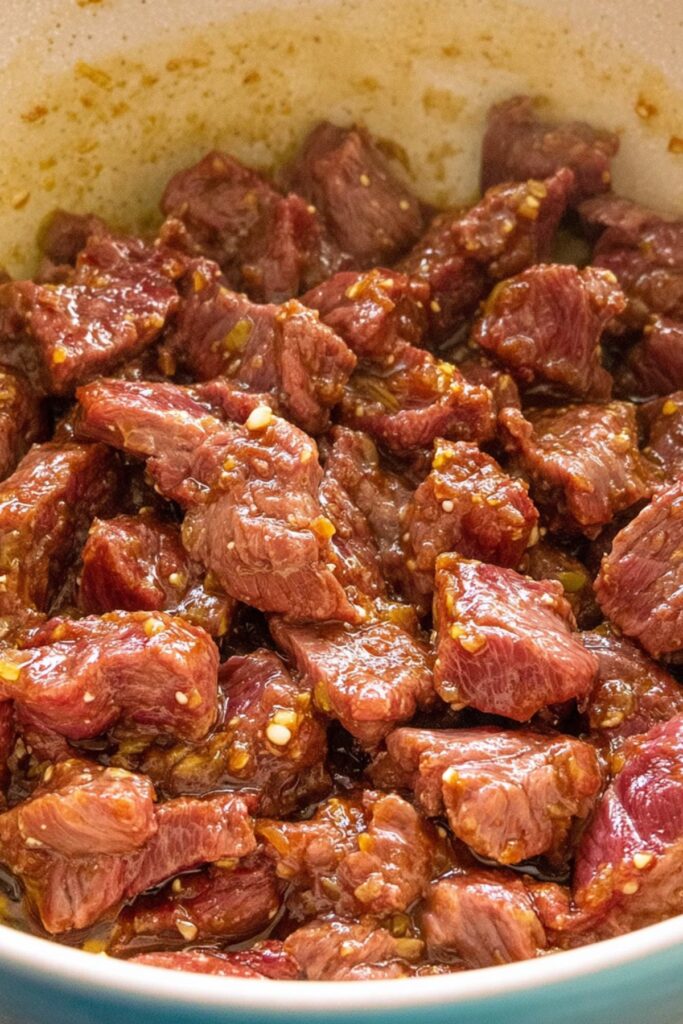 Steak Marinating Process Skirt steak pieces coated in a citrus-garlic marinade in a mixing bowl