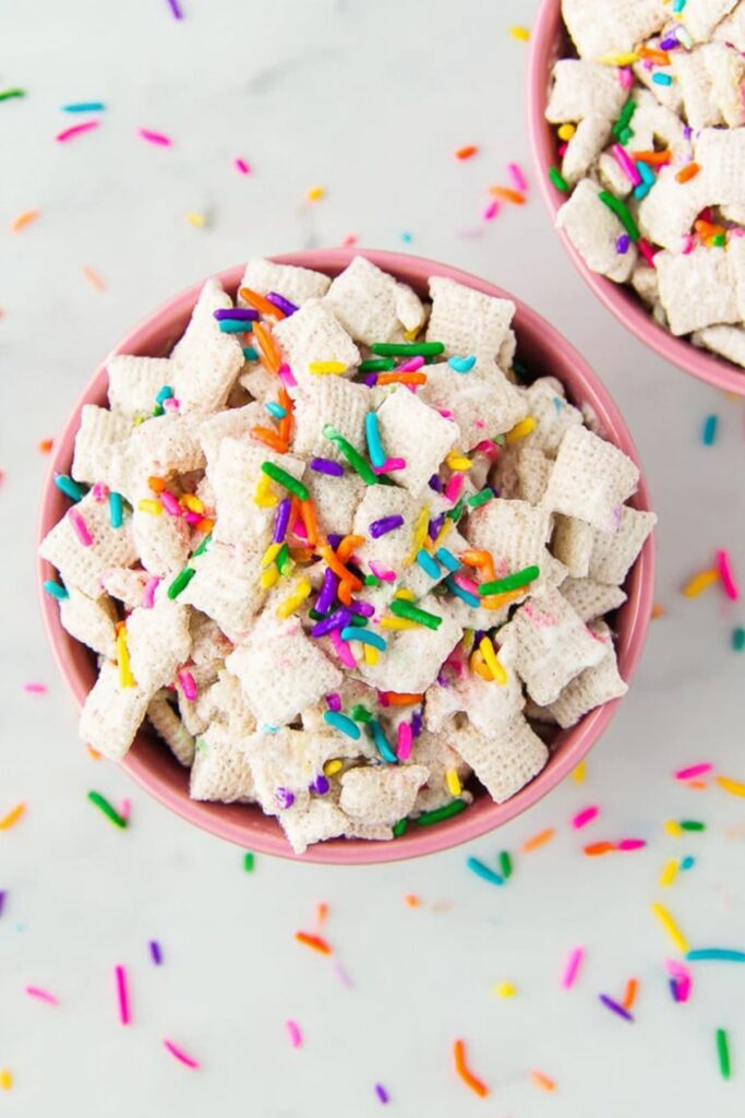 Bowl of Funfetti Puppy Chow Halloween snack with bright sprinkles and crunchy cereal pieces, styled for a party.