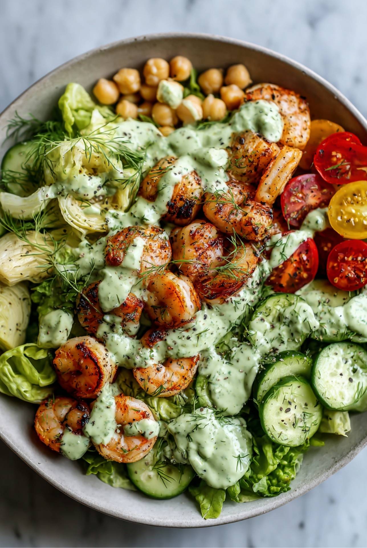 Shrimp salad with cucumbers, tomatoes, chickpeas, and avocado dressing for a high-fiber lunch recipe.