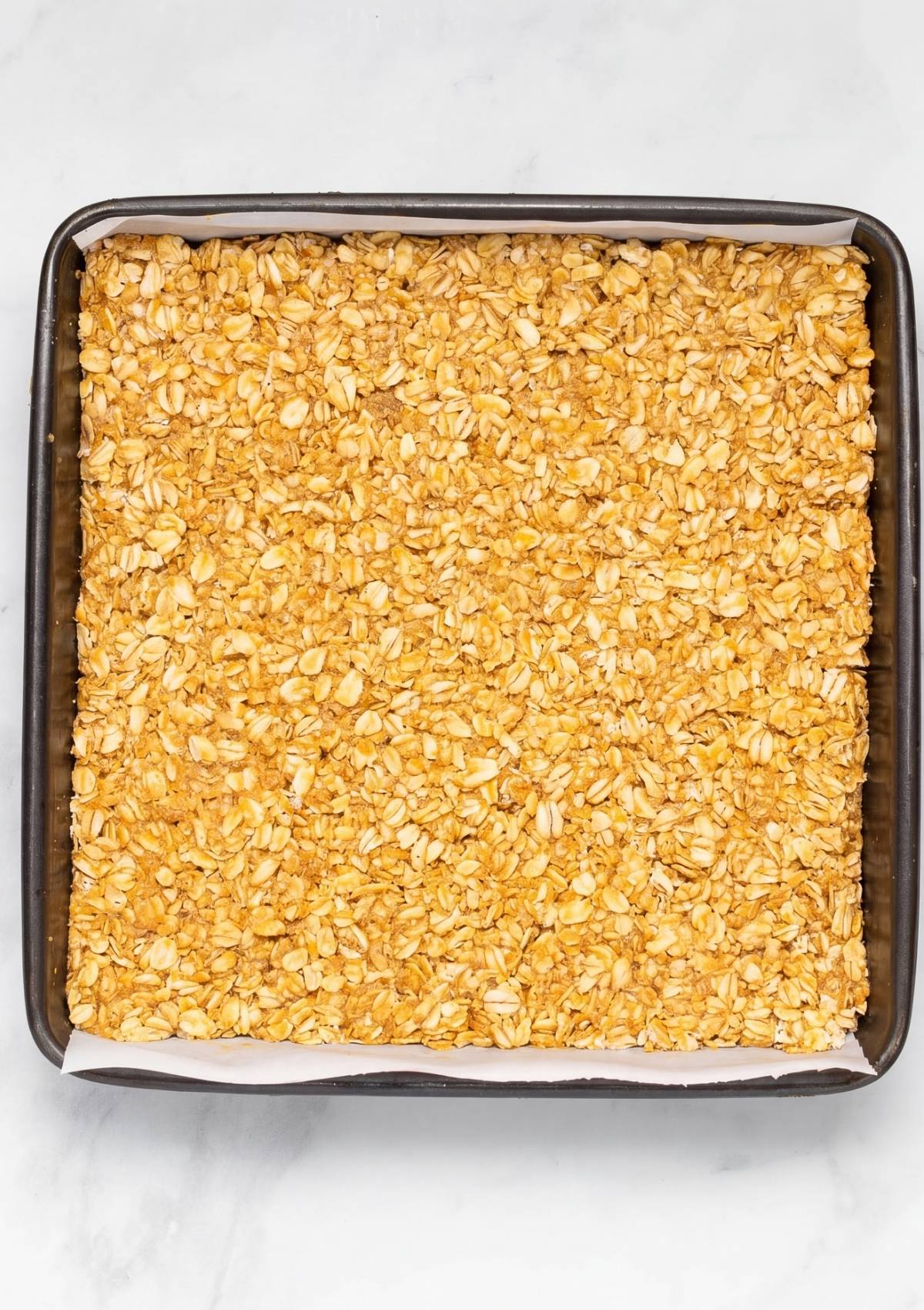 oatmeal peanut butter mixture pressed into pan for no bake bars ready to chill simple recipe step