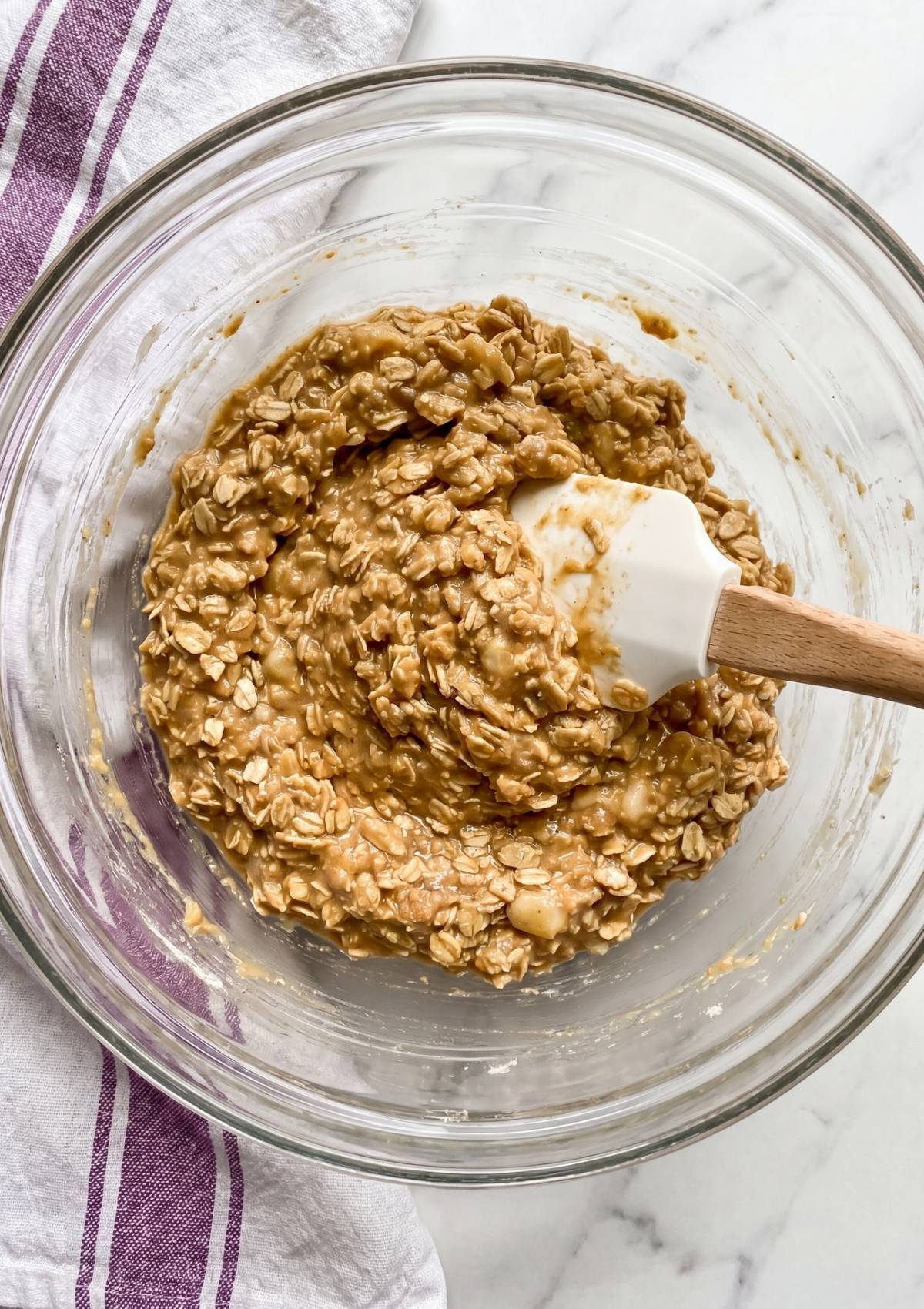 protein no bake cookie dough mixed in bowl with oats peanut butter and banana ready to shape