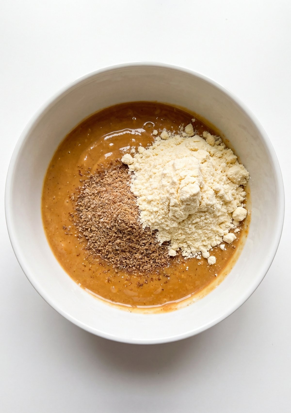 adding protein powder and flaxseed to no bake protein bars mixture step