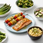 A layout of high-protein dishes including pan-seared salmon, chicken skewers, egg salad, asparagus, and broccoli.